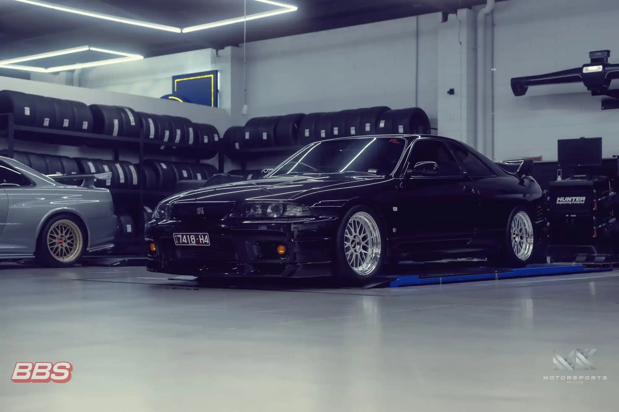 Sleek black Nissan Skyline GT-R with aftermarket wheels.