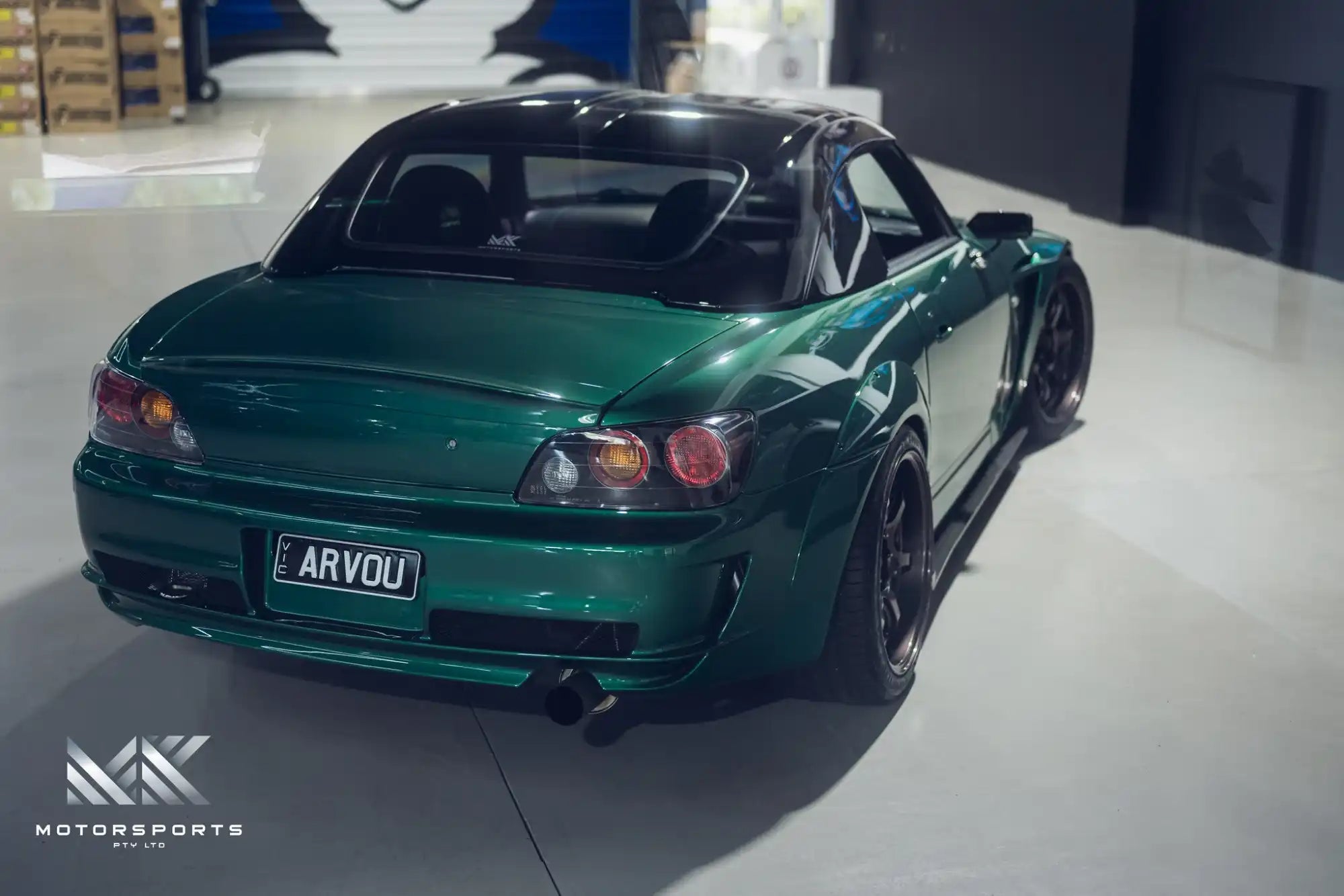 Customized green Honda S2000 sports car with a widebody kit.