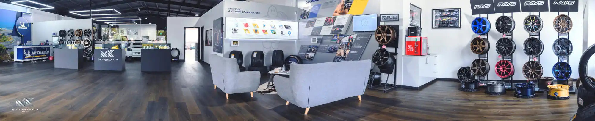An expansive tire and wheel showroom displaying a wide array of rims and tires, with a comfortable waiting area.