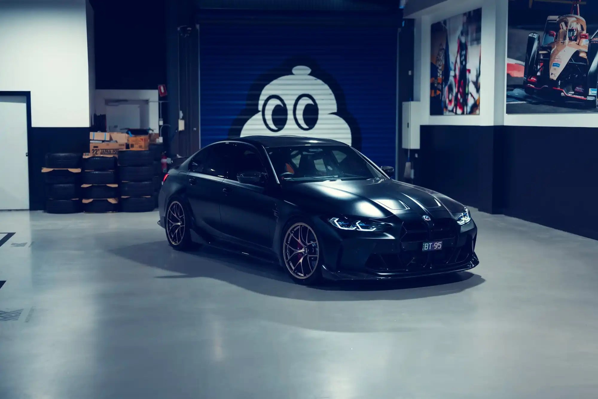Matte black sports sedan with custom wheels.