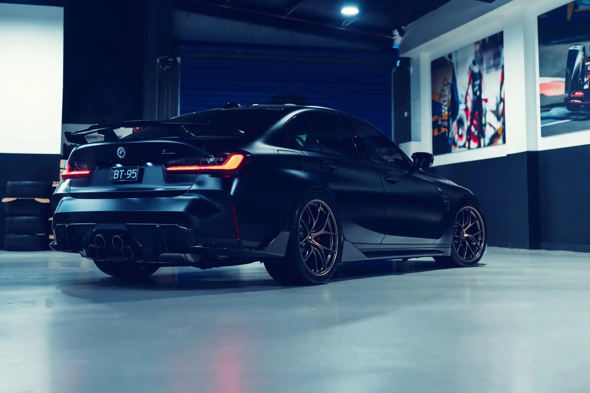 A sleek, dark gray sports coupe with aftermarket wheels and a prominent rear spoiler.