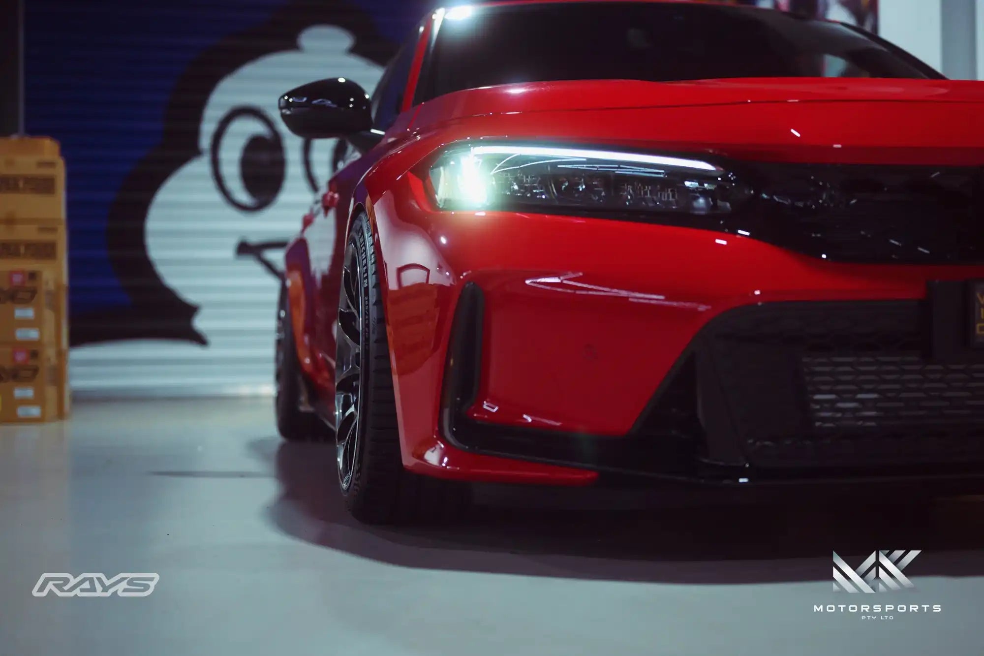 A sleek red sports car with bright headlights.